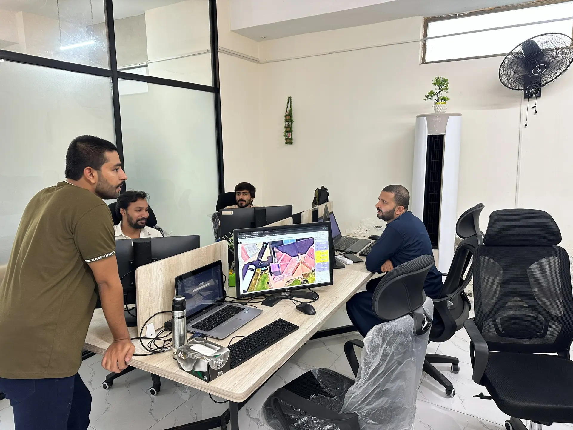 Engineers reviewing a solar roof layout on a large monitor